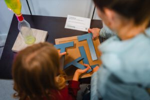 Zusammenlegen eines T-Rätsels am Knobeltisch